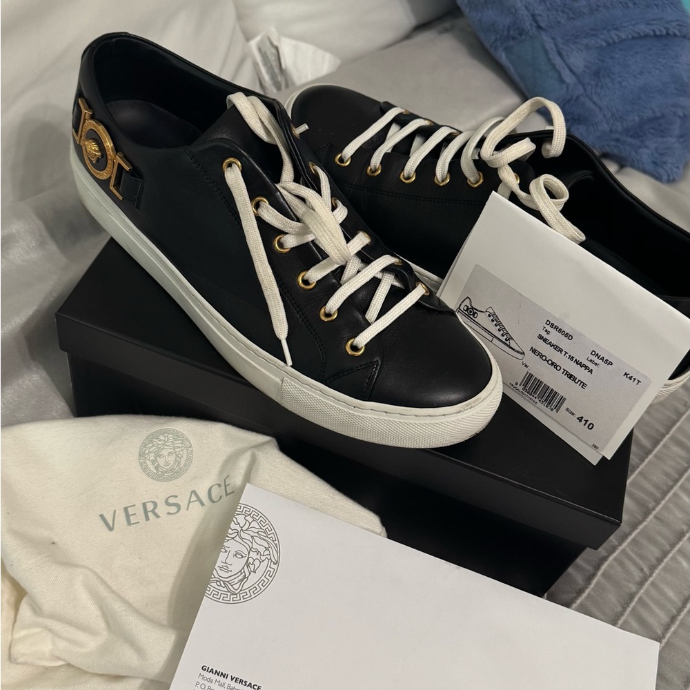 Black sneakers with gold emblem